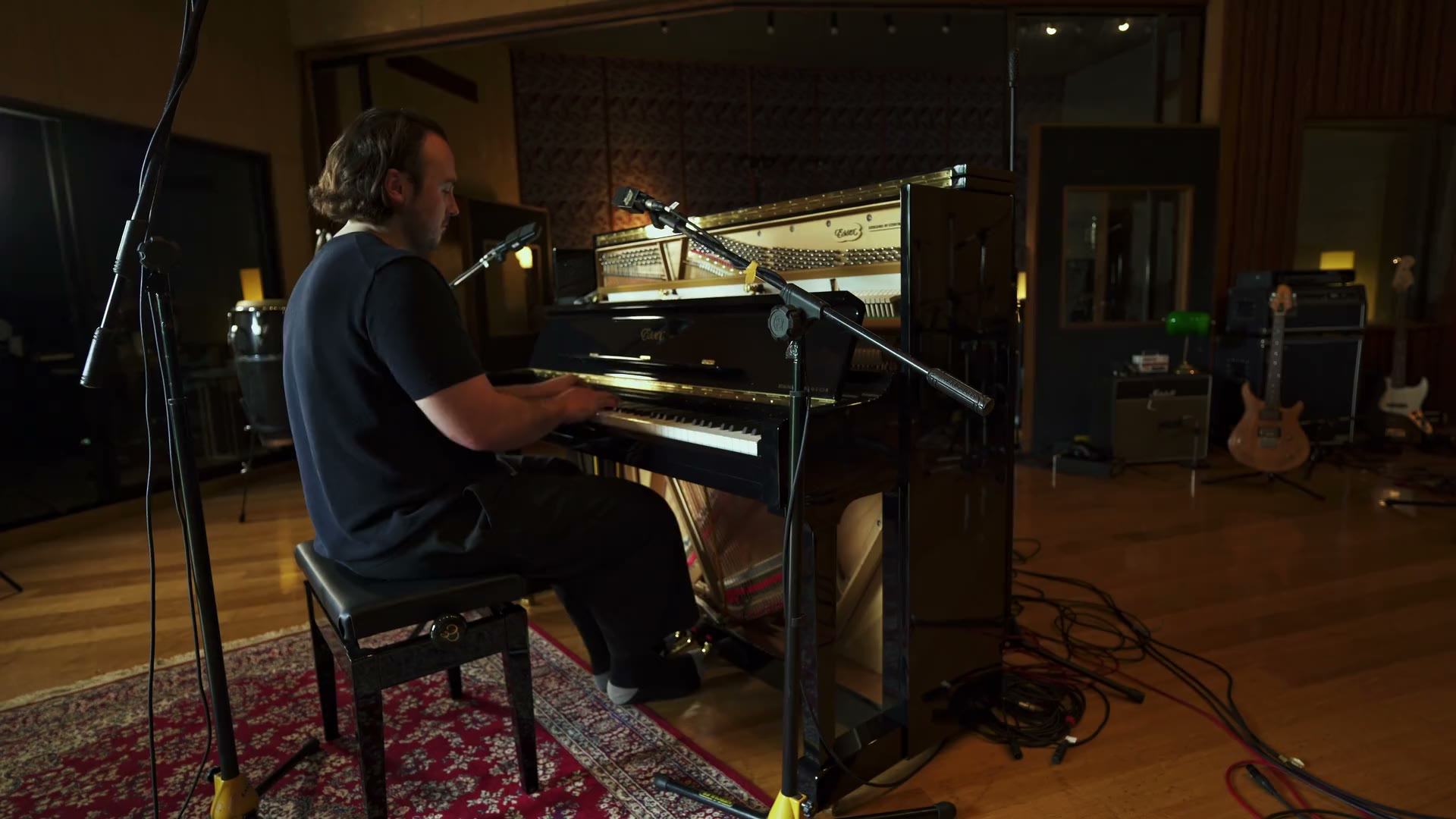 Monty Hancock playing an upright piano in the studio